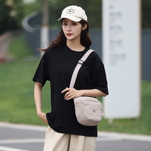 Outdoor shot of stylish beige canvas crossbody saddle bag with casual street outfit
