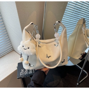 Détail du sac à bandoulière en cuir plissé crème avec papillon argenté et breloque