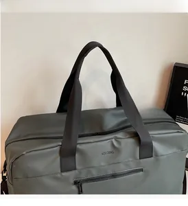 Dettaglio borsa da viaggio grigia in tessuto impermeabile opaco con manici neri e tasca