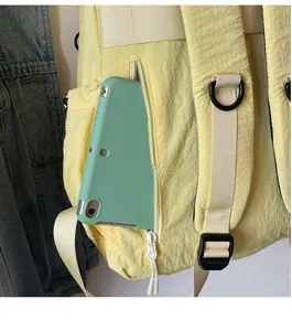 Detail of yellow nylon backpack side pocket showing capacity for a tablet device