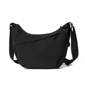 Detail view of black crescent crossbody bag with silver logo and adjustable wide strap