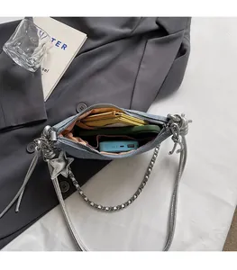 Macro view of denim crescent bag interior showing spacious room for phone and wallet