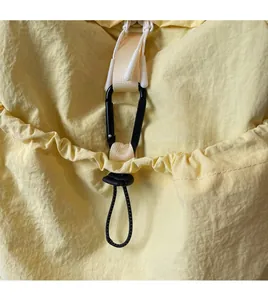 Close-up of durable metal carabiner and drawstring toggle on nylon commuter backpack