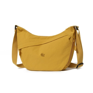 Macro view of mustard yellow water-resistant nylon fabric and metallic logo detail