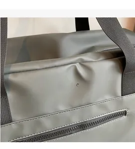 Dettaglio ravvicinato del tessuto grigio della borsa da viaggio con texture impermeabile