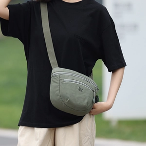 Detail of army green nylon crossbody bag with multi-layer zippers and MS logo