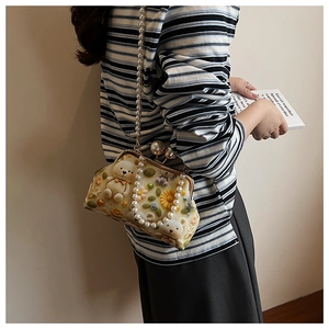 Detail of vintage beige floral doctor bag with 3D teddy bear and pearl strap handles