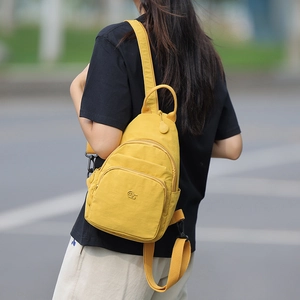 Detail of bright yellow oxford fabric mini crossbody bag with logo embroidery and zip pocket