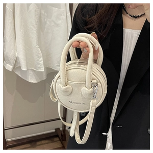 Detail of white round mini bag with litchi grain leather and double top handles