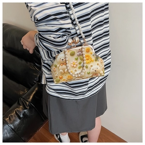 Detail of vintage shell bag featuring teddy bear prints and large pearl chain straps