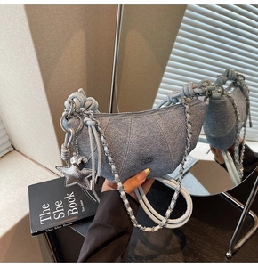 Detailed mirror view of denim croissant bag with silver chain and cute heart charms