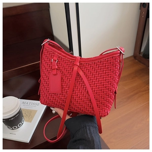 Dettaglio ravvicinato della borsa a spalla in pelle intrecciata rossa con tracolla