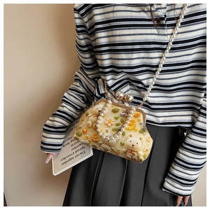 Close-up of small crossbody bag with teddy bear daisy print and pearl chain detail