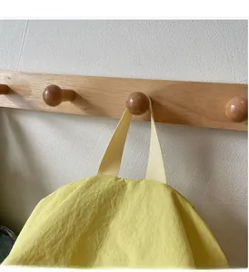 Close-up of bright yellow nylon backpack top with reinforced wide woven handle