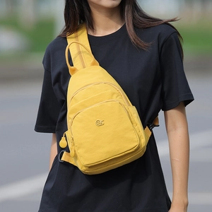 Detail of yellow nylon crossbody bag featuring multiple zipper pockets and metal MS logo