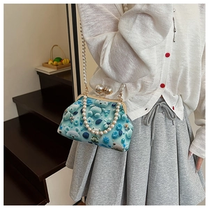 Detail of vintage blue shell bag with pearl chain strap and cute floral bear patterns