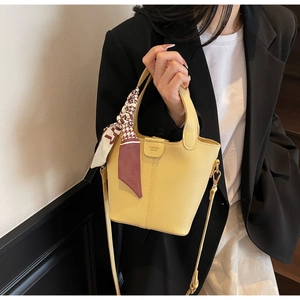 Detail of yellow lychee leather bucket bag with silk scarf and FASHION BAGS stamp
