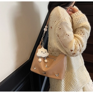 Détail du sac hobo kaki avec décor papillon argenté et pendentif nuage en peluche