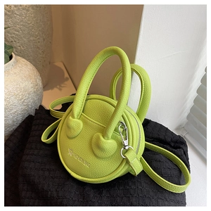 Detail of lime green mini round crossbody bag with star pattern and textured leather