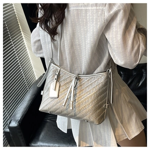 Close-up of woven silver texture on a shoulder bag with metallic finish and strap