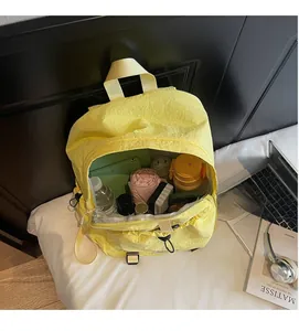 Detail of spacious yellow backpack interior showing storage for bottles and tablet