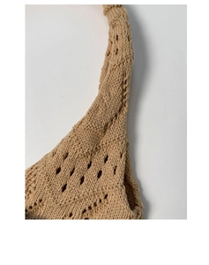 Close-up of khaki crochet knit texture with hollow diamond pattern on a summer tote bag