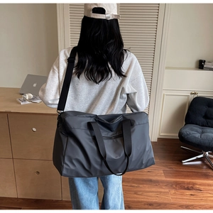 Dettaglio della borsa da viaggio grigia con cuciture rinforzate e trama del tessuto resistente