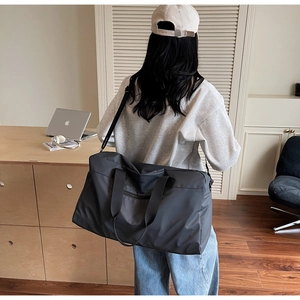 Dettaglio di una grande borsa da viaggio grigia con logo COOLBAG e tracolla regolabile