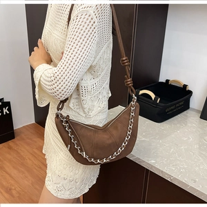 Detail of coffee brown moon bag showing the matte leather texture and silver chain