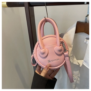 Close-up of pink round mini bag with litchi texture hanging on a wooden hanger