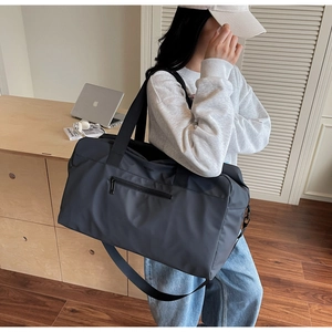 Dettaglio della borsa da viaggio grigio scuro con nylon impermeabile e tracolla