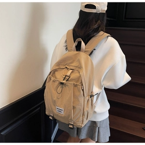 Close-up of beige waterproof nylon backpack with drawstring and metal buckle detail