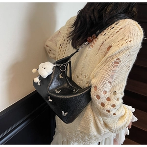 Détail du sac noir Y2K avec rivets papillon argentés et pendentif nuage en peluche