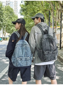 Detail of vintage denim backpacks with multi-pocket structure for casual street style