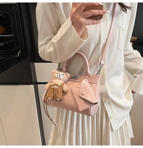Sac à main rose en similicuir avec fermoir rotatif et breloque ours en peluche stylée
