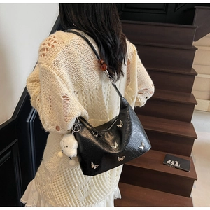 Détail du sac dumpling en cuir noir brillant avec papillons argentés et charme nuage