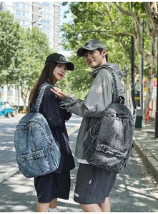 Detailed outdoor shot of vintage denim backpacks in deep blue and smoke grey wash colors