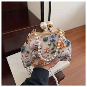 Detail of vintage shell bag with 3D bear floral print and elegant pearl handle strap