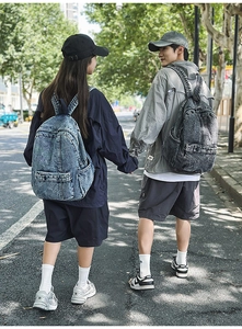 Outdoor shot of minimalist denim backpacks in light blue and grey on models