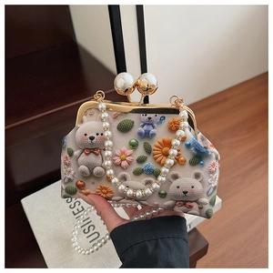 Detail of vintage shell bag with 3D bear embroidery and large pearl clasp closure