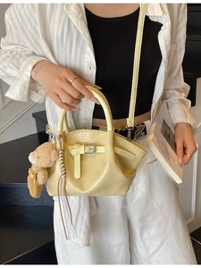 Pale yellow crocodile texture bucket bag with bear pendant and adjustable shoulder strap