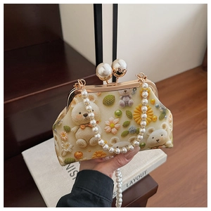 Detail view of the pearl clasp and crochet pattern on a vintage shell bag
