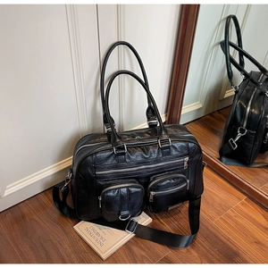 Dettaglio ravvicinato di una borsa vintage nera in pelle PU con tasche multiple su legno