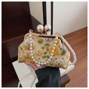 Detail of shell bag with floral bear print, pearl handle and large bead clasp