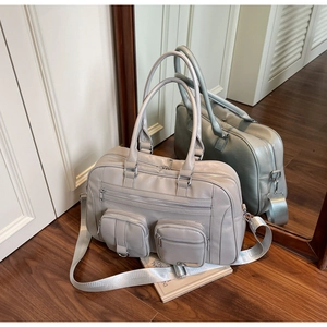 Dettaglio della borsa grande grigio chiaro con tasche a zip e ganci in metallo argentato