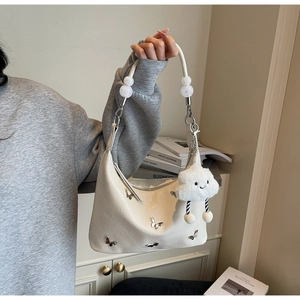 Détail du sac en similicuir litchi blanc cassé avec papillon et poignée perlée