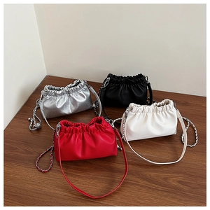 Dettaglio di piccole borse a secchiello con coulisse in argento, nero, rosso e beige