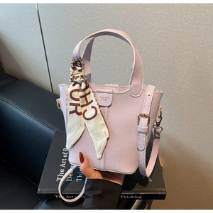 Detail view of light purple bucket bag with lychee texture and decorative silk scarf