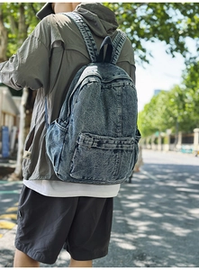 Outdoor lifestyle shot of a vintage washed denim backpack with adjustable straps