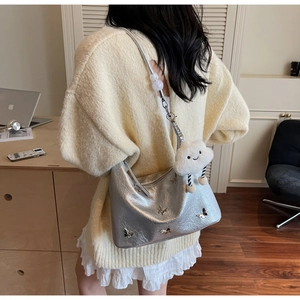 Détail du sac argenté avec décorations papillon et charmant pendentif nuage en peluche